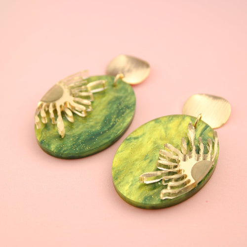 Green marbled earrings with gold leaf design on a pink background