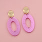 Pink earrings with gold posts on a pink background