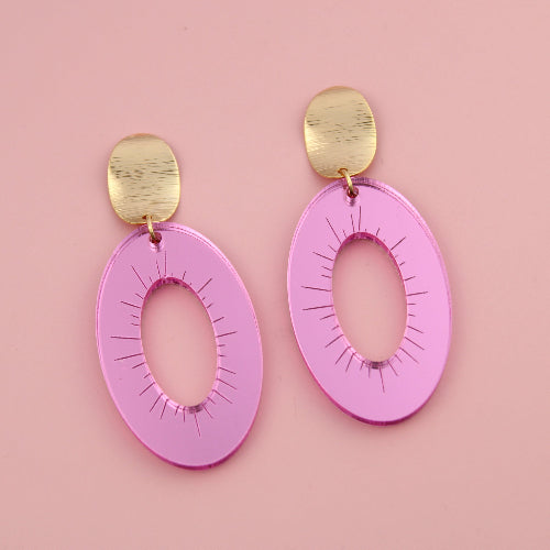 Pink earrings with gold posts on a pink background