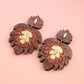 Pair of acrylic earrings with floral design on a pink background