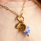 Gold necklace with charms on a beige background