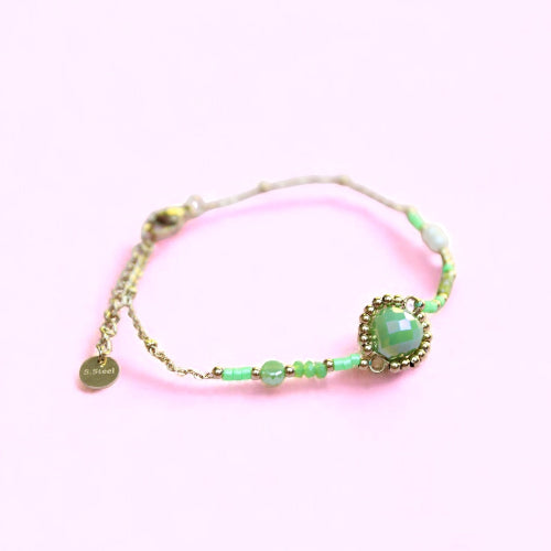 Bracelet with green beads on a pink background